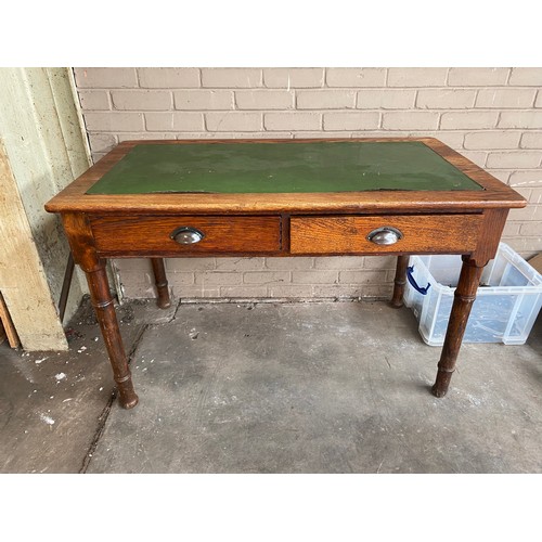 74 - Antique oak and green leather writing desk, fitted with two drawers and turned legs.