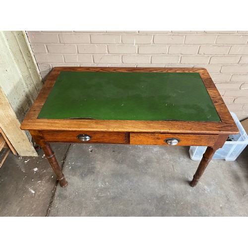 74 - Antique oak and green leather writing desk, fitted with two drawers and turned legs.