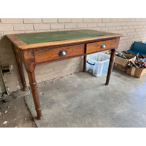 74 - Antique oak and green leather writing desk, fitted with two drawers and turned legs.