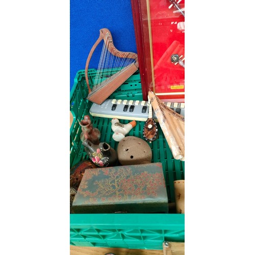 143 - Crate of miniature musical instruments and collectables; Pottery whistles, brass cow bell and tortoi... 