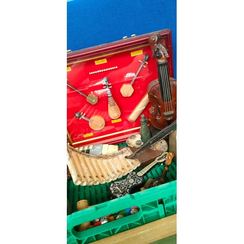 143 - Crate of miniature musical instruments and collectables; Pottery whistles, brass cow bell and tortoi... 