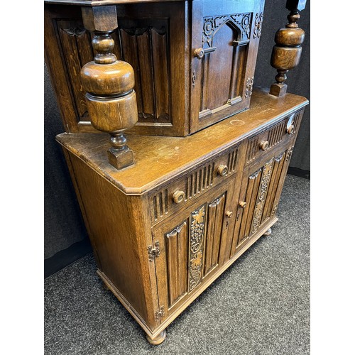 780 - 20th century Oak court cabinet. Vine and grape trims to top section and doors. [147x105x47cm]