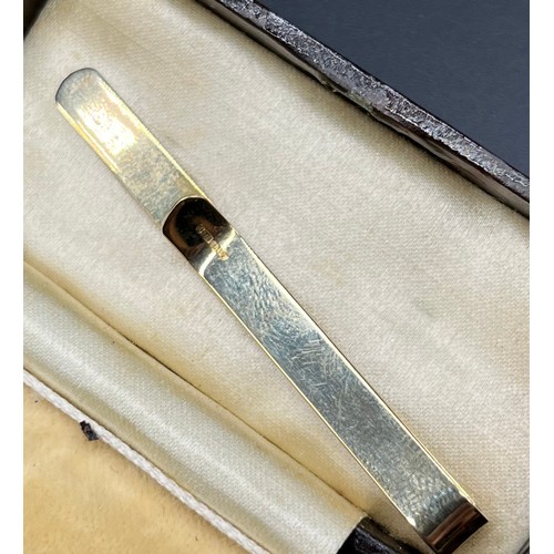 1166 - A Pair of 9ct yellow gold and mother of pearl studs and a 9ct yellow gold tie clip. [5.75grams]