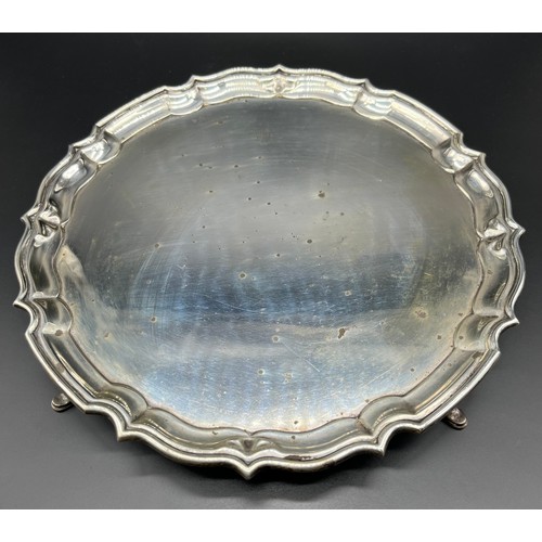 1188 - Birmingham silver serving tray, scalloped edge and supported on four hoof style feet. [26.5cm diamet... 