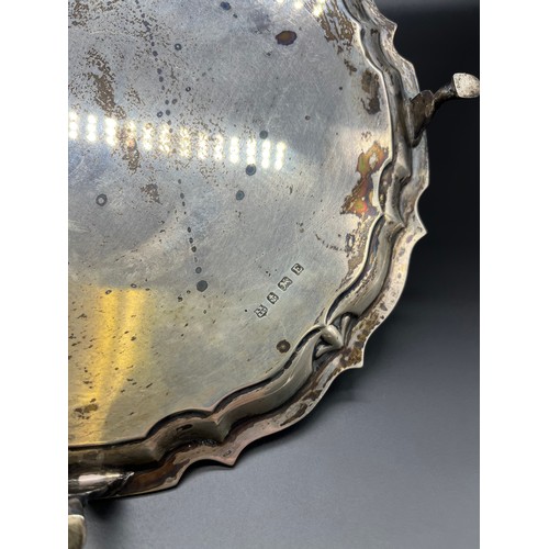 1188 - Birmingham silver serving tray, scalloped edge and supported on four hoof style feet. [26.5cm diamet... 