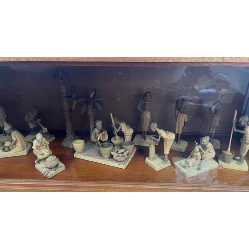 1358 - Wood and glass display case containing a collection of Nigerian Life Wooden carved miniature figures... 