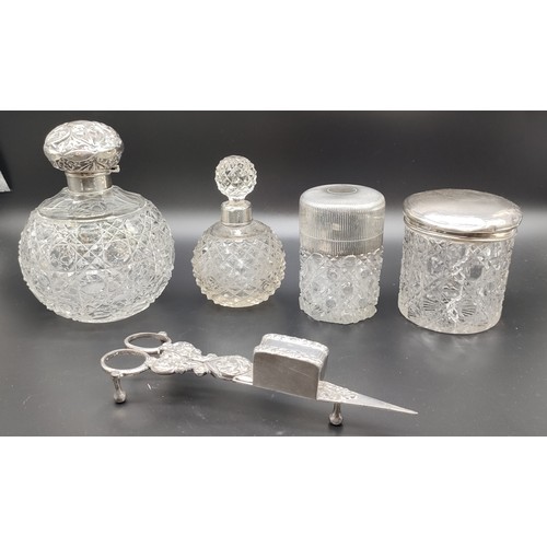 1122 - Four silver and cut crystal perfume bottles and preserve pots; Silver tops and collars. Together wit... 