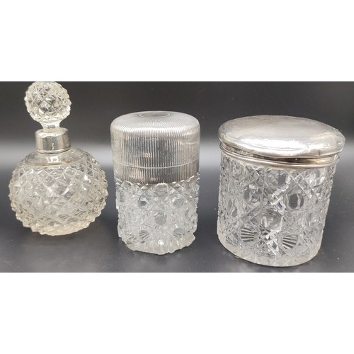 1122 - Four silver and cut crystal perfume bottles and preserve pots; Silver tops and collars. Together wit... 