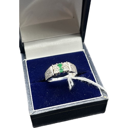 23 - 18ct white gold ring set with white sapphires and green stones. [Ring size L] [5.22Grams]