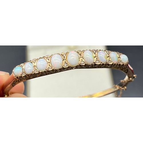 4 - 9ct yellow gold bangle fitted with 9 varying sized opals and small diamond chips [6.62x4.68mm- large... 