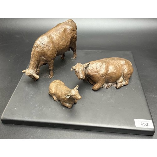 652 - Angela Hunter
Bronzed pottery sculpture of three cows sat upon a slate base. [Base- 35cm square] [Da... 