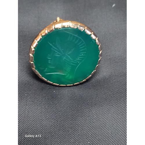 614 - A 9ct gold intaglio fob
The circular green stone carved with a classical armoured head, the gold wor... 