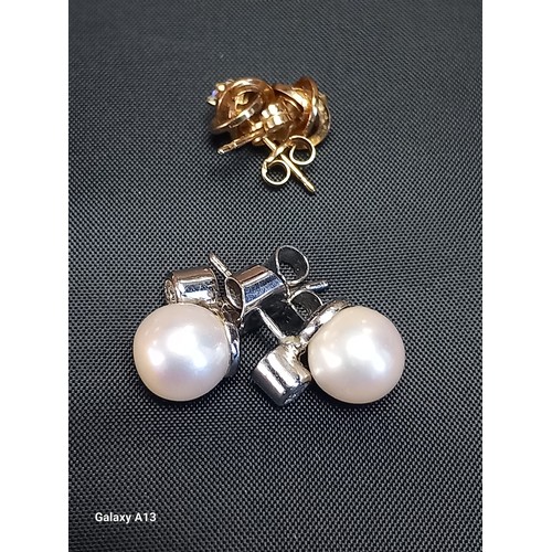 622 - A pair of diamond and pearl ear studs
Collet set diamond below a cultured pearl, white gold post fit... 