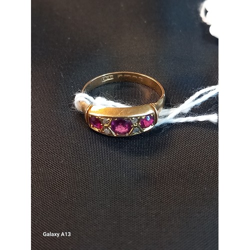 617 - An early 20th century 18ct gold ruby and diamond ring, set three gradated round cut rubies, pair dia... 