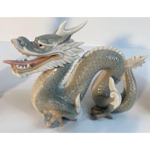 371 - A collection of John Jenkins porcelain dragon figures along with a selection of eastern wooden carve... 