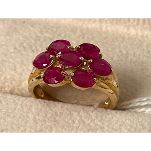 59 - 9ct yellow gold ring set with seven oval cut ruby stones. [Ring size N] [3.50Grams]