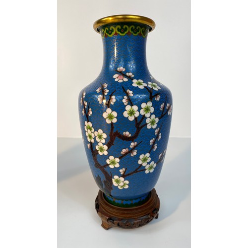 183 - A Pair of cloisonné blue enamelled vases set with tree & bird scene design supported on fruit wood s... 