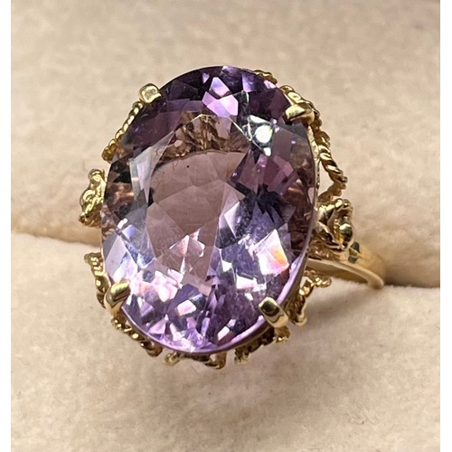 109 - 9ct yellow gold ring set with a large oval amethyst gem stone. [Ring size N] [5.45Grams]