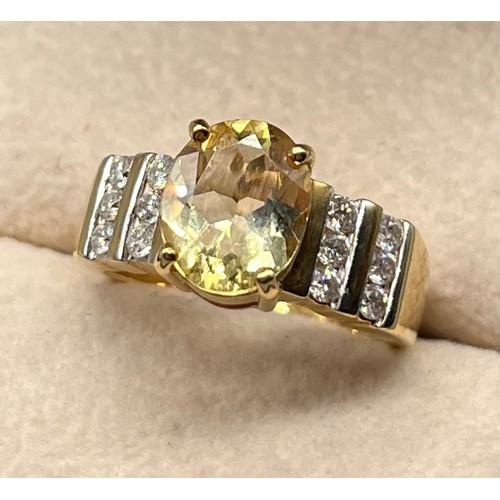 103 - 18ct yellow gold ring set with an oval cut gem and two rows of round cut diamonds to each shoulder. ... 