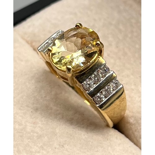 103 - 18ct yellow gold ring set with an oval cut gem and two rows of round cut diamonds to each shoulder. ... 