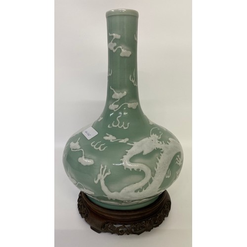 411 - A CHINESE CELADON-GLAZED SLIP-DECORATED 'DRAGON' VASE. Qing Dynasty, 19th Century. Decorated with tw... 