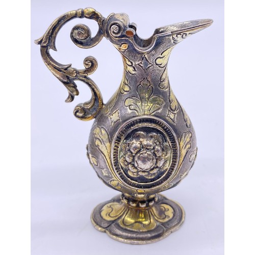 80 - An Italian white metal small ewer Unmarked, bold cast decoration of scroll handle, elongated spout, ... 