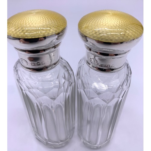 43 - Pair of silver topped perfume bottles, engine turned yellow enamel tops c1915-1920