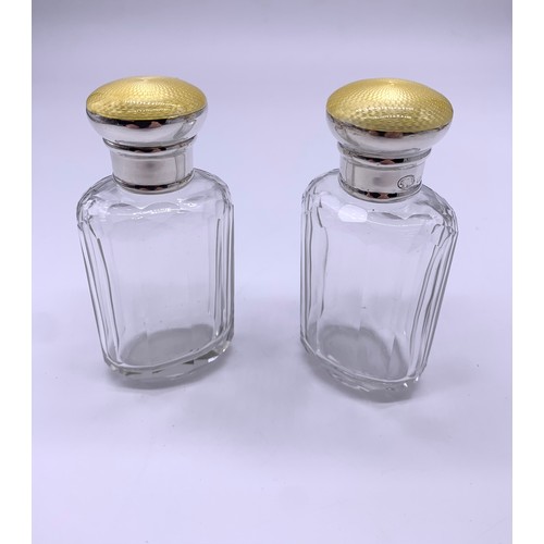 43 - Pair of silver topped perfume bottles, engine turned yellow enamel tops c1915-1920