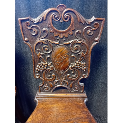 243 - Two 19th Century Oak Carved Hall Chairs with shield and foliate designs