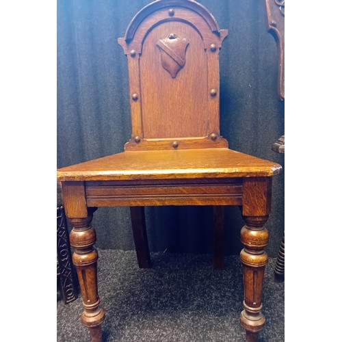 243 - Two 19th Century Oak Carved Hall Chairs with shield and foliate designs