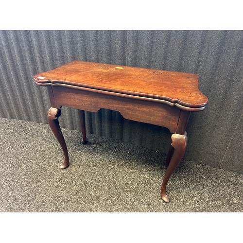 302 - A 19th century mahogany flip top table the shaped surface opening to centre surface with needle work... 