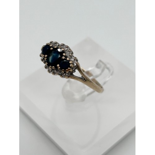 56 - 9ct gold sapphire and diamond cluster ring, the large stone flanked by two smaller ones, surrounded ... 