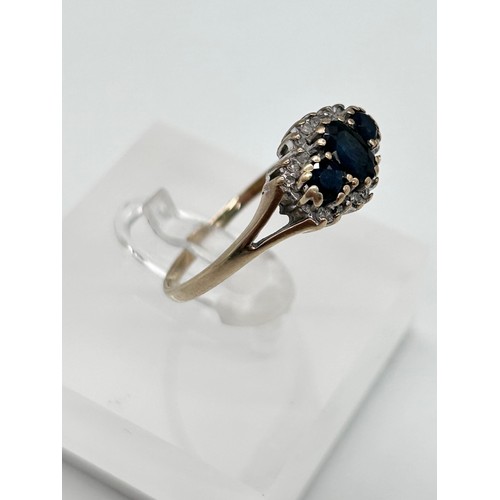 56 - 9ct gold sapphire and diamond cluster ring, the large stone flanked by two smaller ones, surrounded ... 