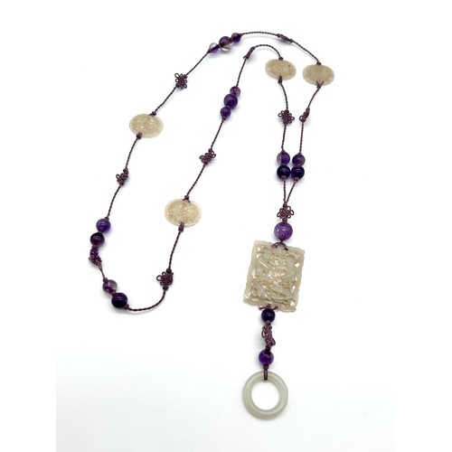 4 - A Chinese jade and amethyst bead long necklace, principal pierced rectangular panel , silk cord with... 