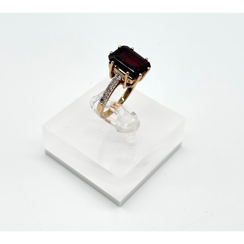 25 - 9ct yellow gold ring with emerald-cut garnet flanked by diamonds, size L [4.40g]