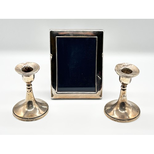 79 - Pair of silver candlesticks, Birmingham 1918 (Weighted) and a silver photo frame, Francis Howard Ltd... 