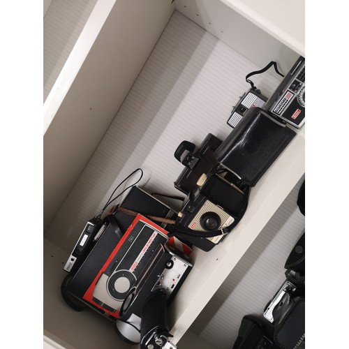 77 - Shelf of vintage cameras.
