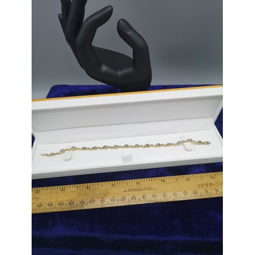 30b - 9ct gold tennis style bracelet with green stones .