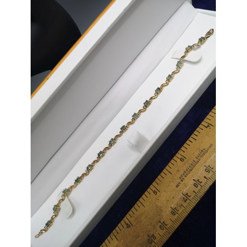 30b - 9ct gold tennis style bracelet with green stones .