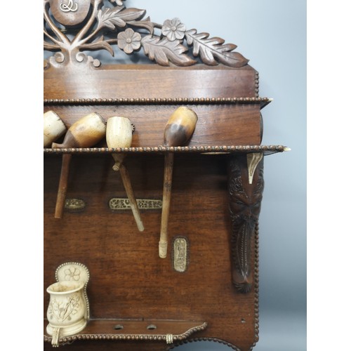 87 - Large black forest heavily carved pipe rack with inlays include s smoking pipes & 1900s bone cup.