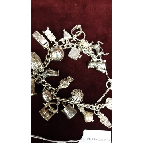 6 - Heavy silver charm bracelet with 22 silver / white charms 88 Grams.