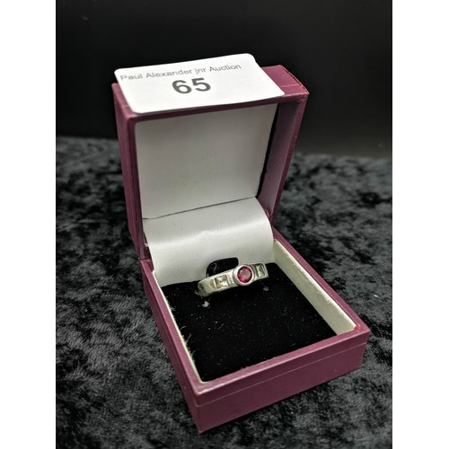 65 - Silver ring set with red stone .