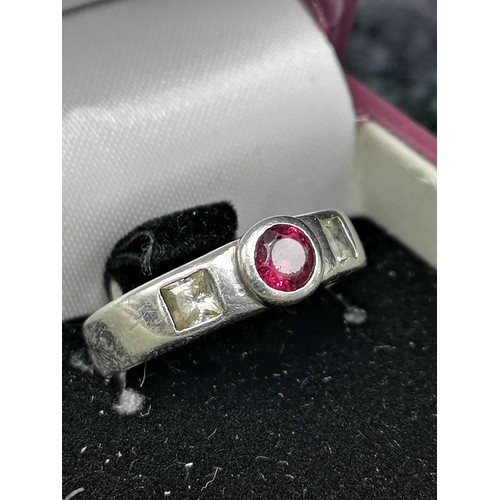 65 - Silver ring set with red stone .