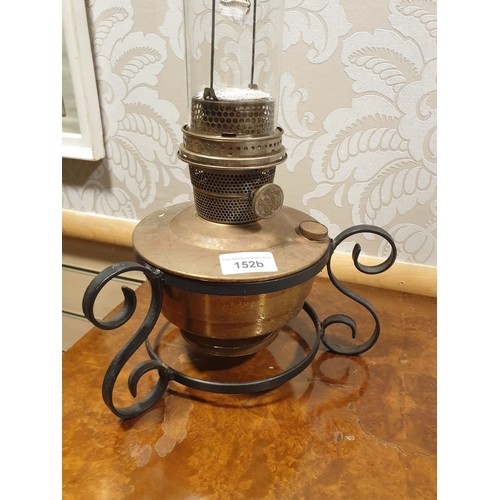 152b - Brass oil lamp set on cast iron support.