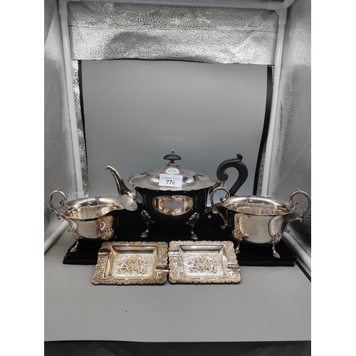 77c - 3 piece silver plated tea set together with silver plated dutch scene dishes .