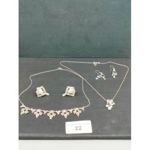 22 - 2 silver necklaces with ornate designs together with 2 sets of silver earrings .