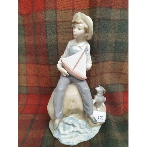 123 - Large Lladro Figure Boy On Rock With Toy Sailing Boat And Dog Stands 24cms Tall