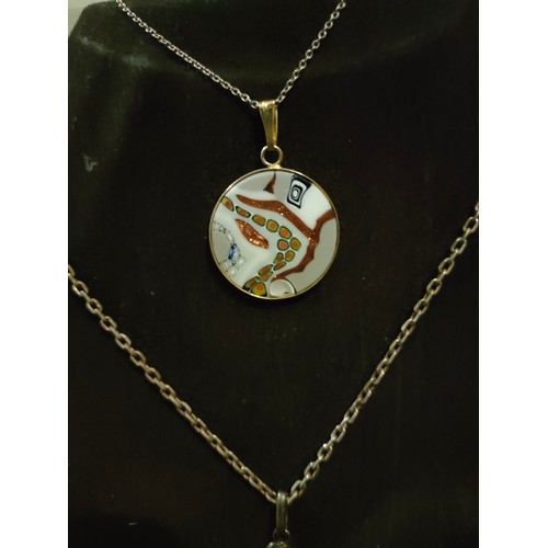 72 - 2 Silver and enamel pendant s with silver chains .