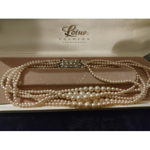 62 - Large string of pearls in fitted case together with pearl and earring set with silver clasp.