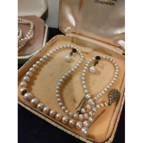 62 - Large string of pearls in fitted case together with pearl and earring set with silver clasp.